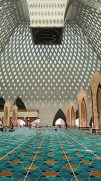 Bandung, Indonesia - July 08, 2026: The beautiful interior architecture of the grand Al-Jabbar Mosque with blue geometric carpets and an iconic dome.