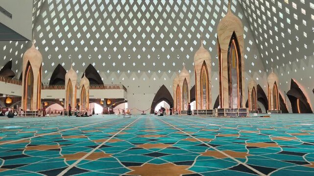 Bandung, Indonesia - July 08, 2026: Majestic atmosphere inside the main hall of Al-Jabbar Grand Mosque with tall pillars and a geometric lattice roof.