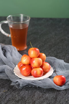Fresh Golden Rainier Cherries with Tea - Healthy Organic Fruit Snack on Dark Surface