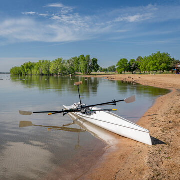 Coastal rowing shell on a shore of Boyd Lake in northern Colorado in early spring scenery.