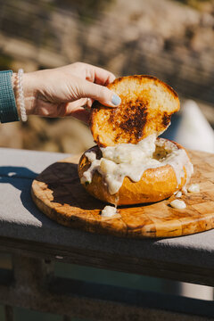 Hand Eating Clam Chowder Bread Bowl