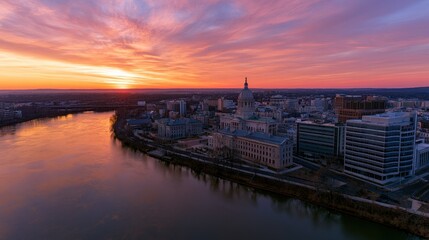 Fototapeta premium Sunset skyline over Trenton, New Jersey: panoramic view of capitol dome and glowing riverfront