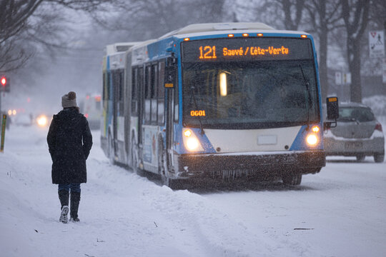 Autobus de Montr&eacute;al dans la neige avec pi&eacute;ton de dos, jour, hiver, horizontal