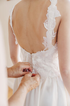 Mother Zipping up her daughter's wedding dress