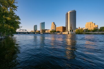 Obraz premium Riverfront panorama of Grand Rapids, Michigan, with modern glass towers reflected on the Grand River