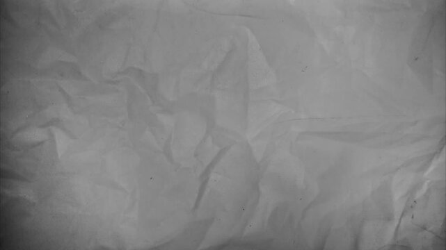 High quality 4K Ultra HD video background featuring a seamless loop of gray crumpled paper texture with subtle analog film grain.