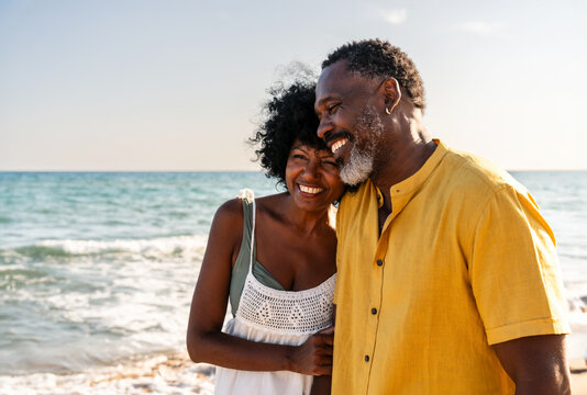 Beautiful mature black couple of lovers dating at the seaside - Married african middle-aged couple bonding and having fun outdoors, concepts about relationship, lifestyle and quality of life