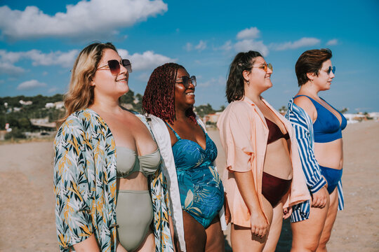 Group of beautiful plus size women with swimwear bonding and having fun at the beach - Group of curvy female friends enjoying summertime at the sea, concepts about body acceptance and body positive 