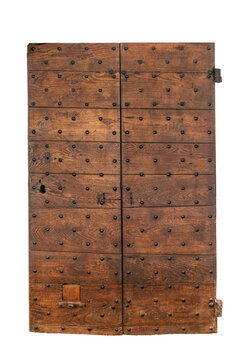 Front view of a weathered antique wooden door with two leaves, reinforced with decorative iron studs and historic blacksmith hardware, dating from the medieval or renaissance period, isolated