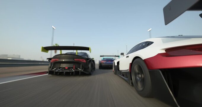 Race cars driving side by side on a racetrack during daytime, close view with motion blur emphasizing speed, clear sky and track details visible