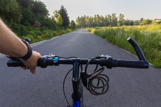First-person perspective of riding a bicycle on an asphalt path commuting to work in the morning