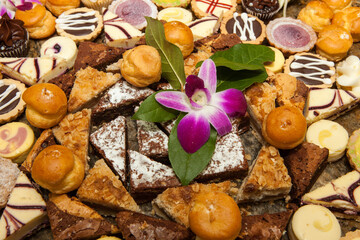 Fototapeta premium Assorted Dessert Platter Pastries Brownies Orchid Garnish Buffet Party