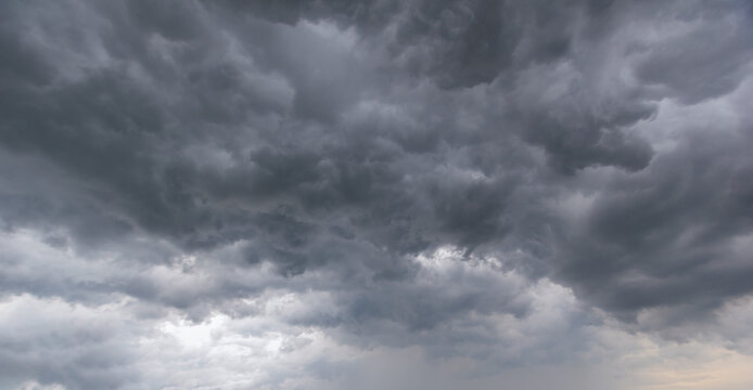 Dramatic dark clouds gathering in the sky before a heavy rainstorm. Atmospheric background representing gloomy weather, natural power, climate change, and moody overcast environments.