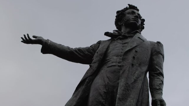 Bronze monument of Alexander Pushkin against a cloudy gray sky
