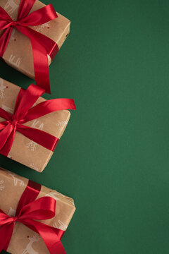 Christmas gifts wrapped in craft paper with red ribbons