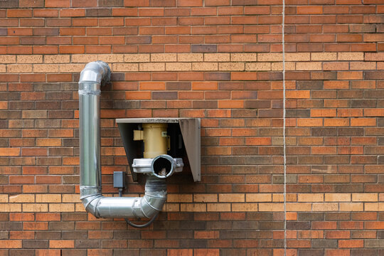 Industrial ventilation exhaust pipe on brick wall