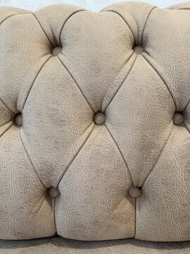 Brown tufted leather upholstery texture background with intricate stitching pattern