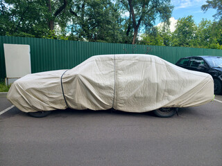 Nylon car cover on vehicle parked in residential yard protecting from UV rays and environmental damage © Harmony Video Pro