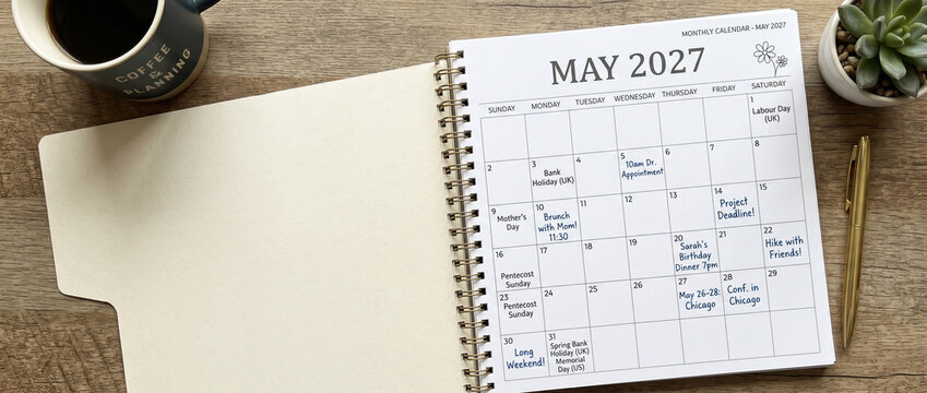 Vue du dessus d'un agenda ouvert affichant le calendrier de mai 2027 sur un bureau