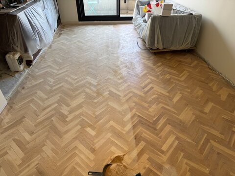 Newly sanded parquet flooring in a room under renovation