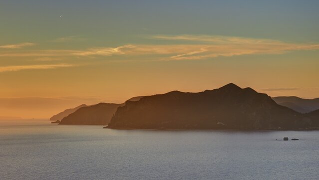 Sunset, dusk, rocky coasts in a row, sandy and blue sky, Pentati, village above Agios Gordios bay, Corfu island, Ionian Islands, Greece