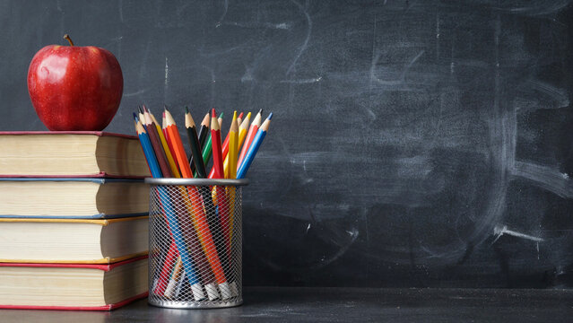 Colored pencils on chalkboard background for creative art and school supplies presentation