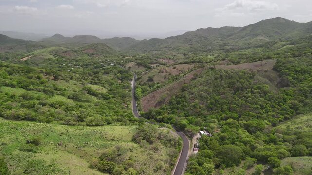 Long asphalt road among green hills landscape in Nicaragua aerial drone view