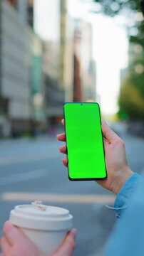Woman is standing on the street and using smartphone with green screen
