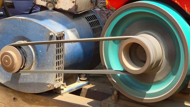 Industrial electric motor with rotating belt drive system in a workshop