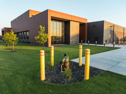 Aerial Drone Shot of Geothermal Wellhead with Yellow Safety Bollards Outside Modern Corporate Building