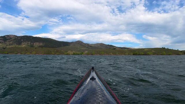 Immersive POV kayaking across Horsetooth Reservoir in Fort Collins, Colorado, while paddling into a strong headwind. Experience challenging summer conditions as a carbon fiber kayak cuts through waves