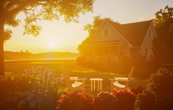 Cozy cottage house backyard with patio chairs at warm golden sunset
