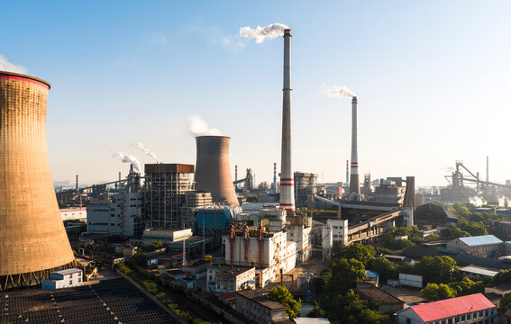 Wuhan Thermal Power Plant featuring gaint nuclear-style cooling towers and smokestacks, emitting heavy steam. It uses ultra-low emission, cogeneration for green energy transition. China.	