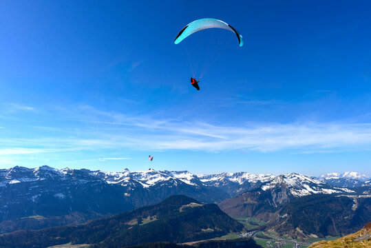 Gleitschirmflieger im Bregenzerwald mit Blick auf die Gemeinde Au und das imposante Massiv des Diedamskopfs, Vorarlberg, &Ouml;sterreich