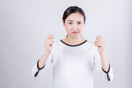 Young woman with doubtful disgusted expression and hand gesture in studio