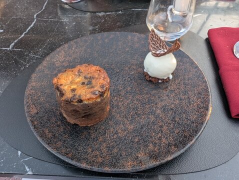 Close-up of a chocolate muffin and vanilla ice cream with a chocolate lattice on a dark plate at Caf&eacute; Kessabine Medina in Marrakesh, Morocco.