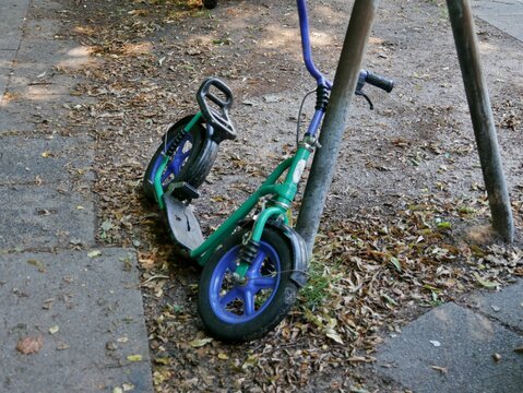 Kinderroller lehnt an Stange