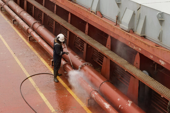 usage of hydro blaster lance at cargo ship conduit lines while removing aged protective coating and rust as part of routine maritime maintenance
