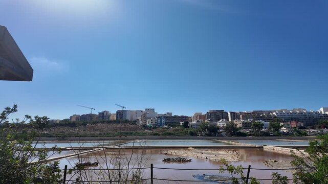 Salina, Malta - 06.07.2026 - Salina Nature Reserve, View of salt pans with buildings to the rear in Salina Bay, Bugibba, Malta.