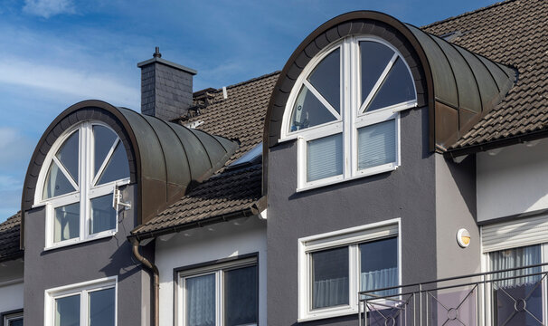 Building facade showing rounded dormer windows and tiled roof