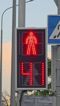 Traffic signal shows green pedestrian light for walking at a crosswalk in a city
