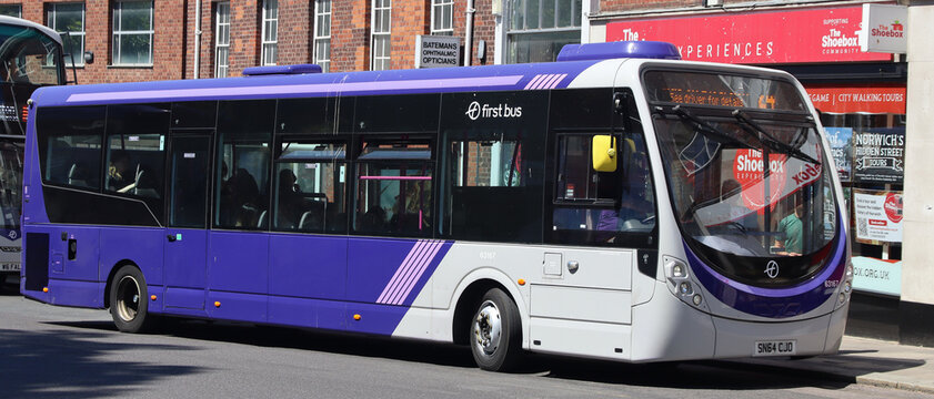 Norwich, United Kingdom - July 5, 2026: General street view in Norwich city centre Modern purple and white bus on during daytime with buildings advertisements background