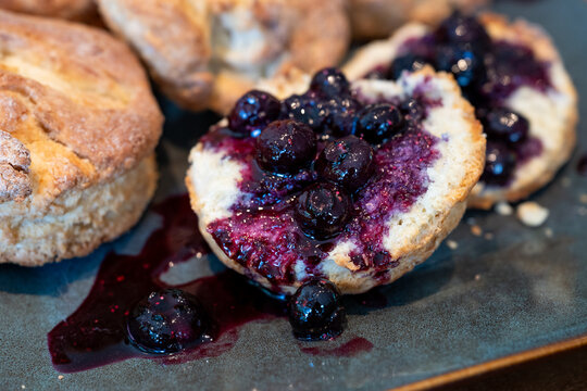 Homemade biscuits on a square platter, split open and topped with hand crafted blueberry sauce, delicious summer food treat
