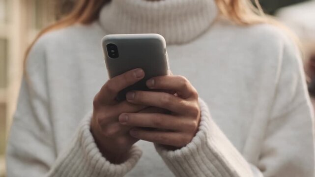 young woman texting on mobile phone. close up Young woman reading a message on the phone in the city.
