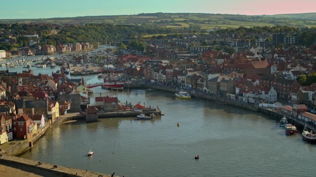 Beautiful panoramic aerial shot of Whitby harbour with boats sailing along the river Esk