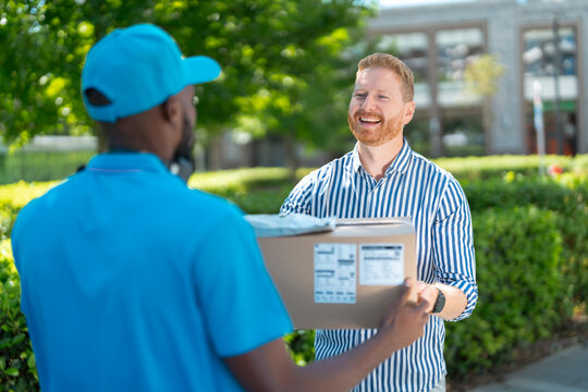 Happy customer receives a parcel from a courier during a successful last-mile delivery.