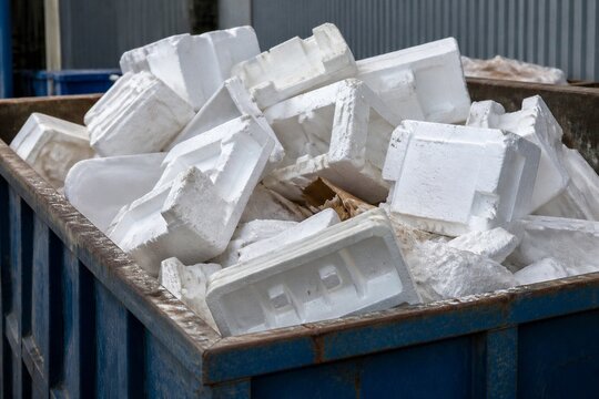 Styrofoam blocks piled and discarded in metal dumpster