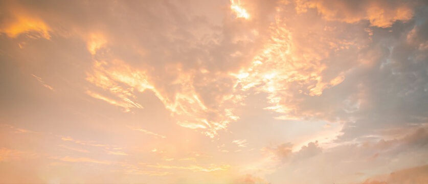 Beautiful sunset sky background with dramatic golden light sunbeams and warm orange cumulus clouds for panoramic travel mockup design