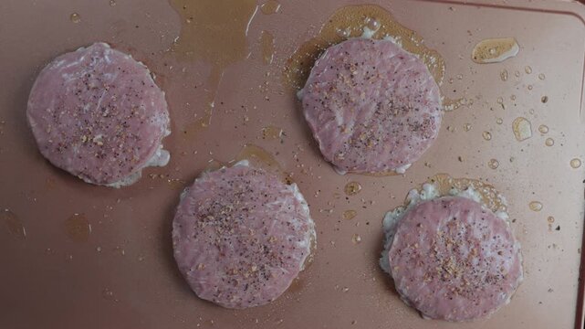 Four seasoned turkey burger patties sizzling on a hot griddle