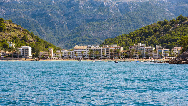 Port de Soller coastal town with white buildings and turquoise sea, Mallorca
